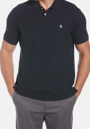 Granatowa koszulka polo z bawełny, z plisą na trzy guziki i małym logo na piersi. Krótkie rękawy z bocznymi rozcięciami dla wygody.