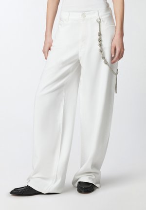 Pantaloni bianchi a gamba larga con una texture liscia, caratterizzati da un accento di catena argentata attaccato all'asola della cintura e una chiusura con bottone.