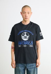Sort bomulds t-shirt med et centralt fodboldgrafik og blå tekst. Kortærmet og afslappet pasform med rund halsudskæring.