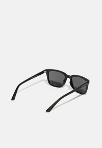 Ochelari de soare negri cu o formă rectangulară și lentile întunecate. Fabricati din plastic elegant, având accente argintii și detalii cu logo pe brațe.