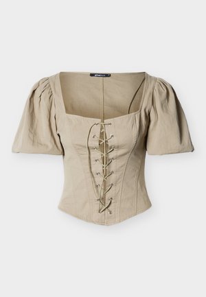 Corset beige avec un décolleté carré, des manches courtes bouffantes et un devant à lacets avec œillets argentés et lacets verts. Tissu texturé.