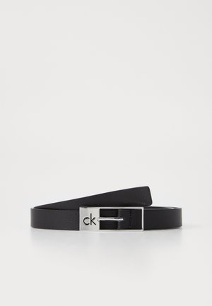 Zwarte leren riem met een kleine zilveren rechthoekige gesp gegraveerd met het "ck" logo, getoond opgerold op een witte ondergrond.