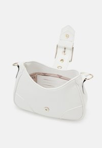 Sac à épaule en cuir blanc avec boucle dorée et fermoir à pression, ouvert pour montrer l'intérieur rose clair et les emplacements pour cartes à l'intérieur.