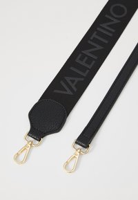 Black strap featuring a textured leather base and a central canvas section with "VALENTINO" in black. Gold metal clips at each end.