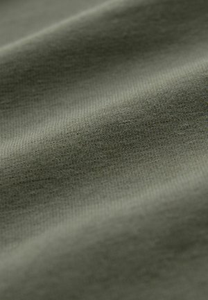 Textured fabric in olive green, showing fine knit patterns and a smooth, soft surface with slight sheen and rippling folds.
