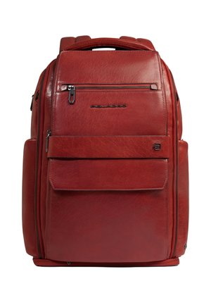 Sac à dos en cuir rouge avec plusieurs compartiments zippés, poche à rabat frontale et poignée supérieure, présenté sur fond blanc.