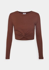 Hnědý žebrovaný crop top s dlouhým rukávem, který se vyznačuje předním uzlem, kulatým výstřihem a přiléhavým střihem. Měkká textura s elastickým materiálem.