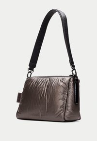 Sac à main gris métallique avec une texture froissée, doté d'une bandoulière noire texturée. Fermeture éclair sur le dessus et poche latérale.