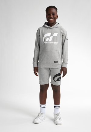Grijze hoodie en short set met een groot zwart "GT" logo en tekst. Het materiaal lijkt een zachte katoenmix; inclusief capuchon met trekkoord en zakken.