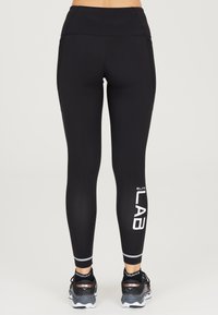 Leggings sportivi neri con vita alta, dotati di pannelli in rete laterali, dettaglio del logo bianco sulla parte inferiore della gamba e tessuto testurizzato.