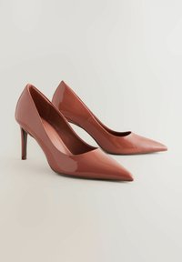 Zapatos de tacón alto en un brillante rosa chicle, diseño de punta afilada, textura suave, con un tacón delgado. Estilo minimalista sin acentos adicionales.