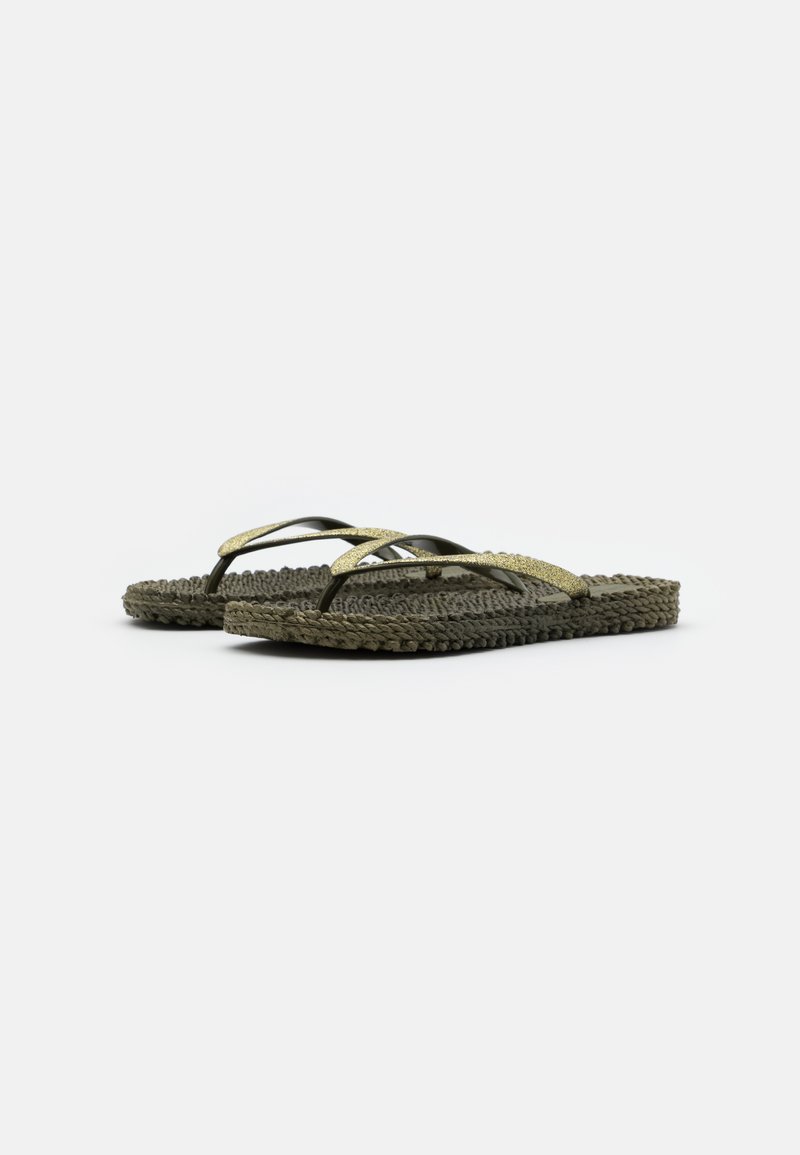 Par de sandalias tipo chancla tejidas en color oscuro con suelas texturizadas y finas correas metálicas doradas, mostradas lado a lado sobre un fondo blanco liso.