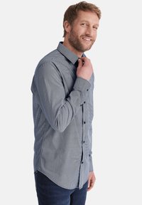 Blau-weißer gestreifter Button-Up-Hemd mit Kragen, langen Ärmeln und schwarzen Knöpfen. Strukturierter Stoff mit abgerundetem Saum-Design.