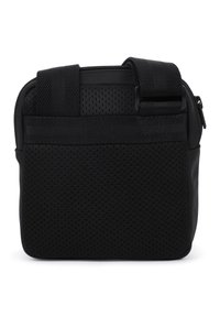 Μαύρη τσάντα με υφή διάτρητης επιφάνειας, ενισχυμένες ραφές και ρυθμιζόμενους ιμάντες. Κλείσιμο με φερμουάρ στο πάνω μέρος για ασφαλή πρόσβαση.