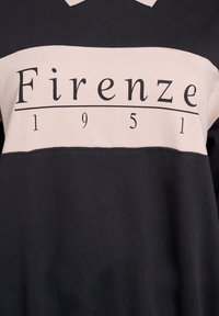 Svart och krämfärgad sweatshirt med en djärv "Firenze"-tryck, år "1951," med en mjuk textur och färgblockdesign.