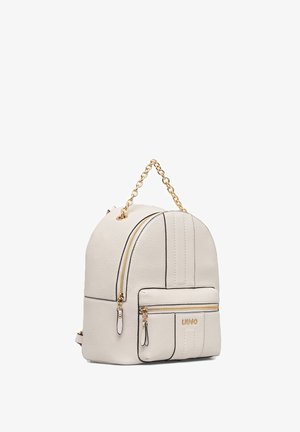 Piccolo zaino in pelle color crema con tasca frontale con zip, manico a catena dorata e dettagli con cerniere dorate.