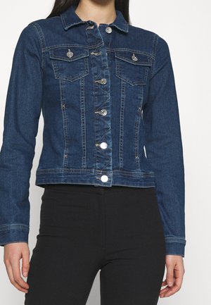 Tummansininen farkkutakki pitkillä hihoilla, kahdella rintataskulla ja hopeisilla napitusvaihtoehdoilla. Teksturoitu kangas ja lyhyt malli.