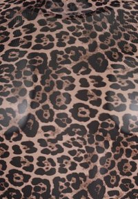 Tkanina s leopard printom s glatkom teksturom koja sadrži velike crne točke na svijetlosmeđoj pozadini, stvarajući odvažan, životinjski inspiriran uzorak.