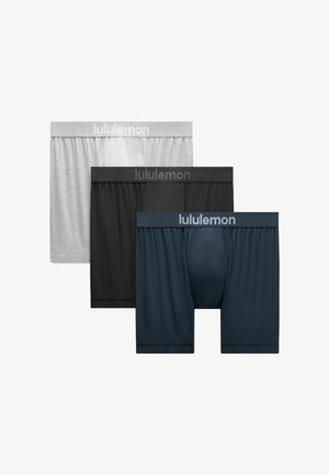 Trys Lululemon vyrų bokserčių poros pilkos, juodos ir tamsiai mėlynos spalvos, išdėstytos viena ant kitos ant balto fono.