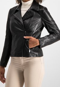 Černá kožená motorkářská bunda s klopovým límcem, asymetrickým zipem a kapsami na zip. Hladká textura a přiléhavý střih.
