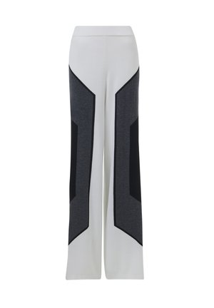 Weiße weite Hose mit dunkelgrauen und schwarzen geometrischen Seiteneinsätzen, ausgestattet mit einem elastischen Bund und einer weichen Stoffoberfläche.