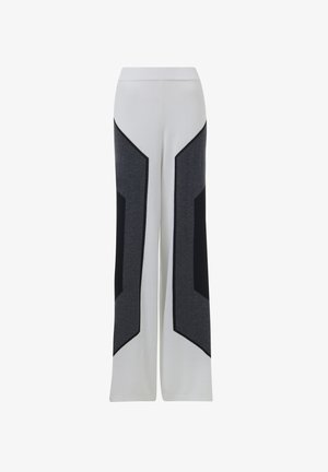 Witte wijde pijpen met donkergrijze en zwarte geometrische zijpanelen, voorzien van een elastische tailleband en een zachte stoftextuur.
