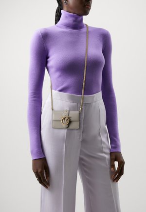 Purple fitted turtleneck sweater paired with light gray pants. Accessory includes a small gray crossbody bag with a gold chain and decorative hardware.