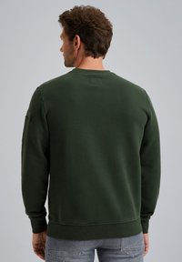 Donkergroene sweatshirt met lange mouwen, ribgebreide manchetten en zoom, label op de achterkant van de hals, en een zijzak op de linker mouw. Zachte stoftextuur.