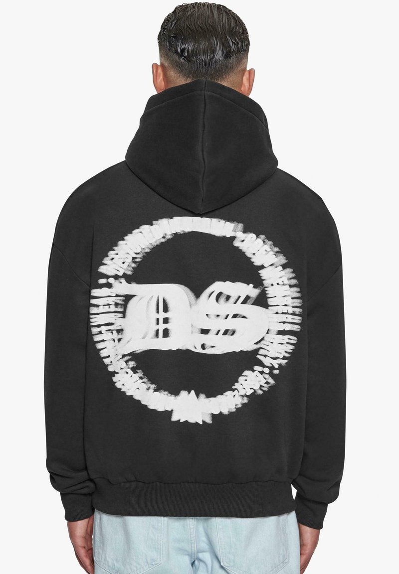 Felpa nera con cappuccio con una grande grafica bianca sulla parte posteriore che presenta le lettere "DS" in un design circolare. Il tessuto sembra morbido.