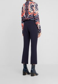 Námornické kalhoty s rovný cut, se bočními rozparky na lemu, spárované s vzorovaným multicolor dlouhým rukávem.