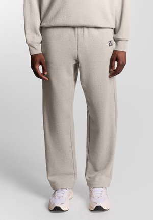 Lys grå sweatpants lavet af blødt stof, med en taljebånd og diskret logo-patch, i en løs pasform og lige ben design.