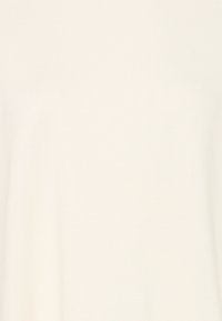 Tissu côtelé beige clair avec une texture lisse, présentant un design simple et sans ornement. Aucun motif visible ni élément métallique.