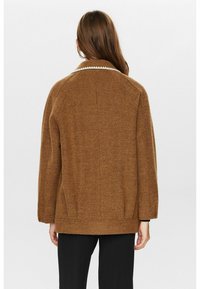 Veste en laine marron avec un col côtelé et des poches latérales, arborant une coupe ample et une surface texturée, vue de dos.