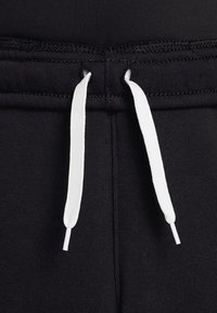 Pantalones de chándal negros con una tela texturizada, cinturilla elástica con cordones blancos y costuras reforzadas en la parte superior.