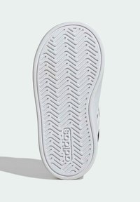 Bílá pryžová podrážka tenisky se vzorem zubatého běhounu a vtisknutým logem "adidas". Hladká textura, zaoblený tvar a mírné zakřivení na okrajích.