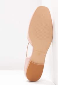 Chaussure plate beige unique avec un bout carré, une semelle lisse et une bride à la cheville, vue par le dessous, taille 37, fabriquée en Espagne.