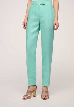Pantaloni din in verde mentă cu un croi ajustat, având pliuri frontale, buzunare laterale și o textură netedă. Asortați cu tocuri aurii cu barete.