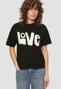 Czarny bawełniany T-shirt o luźnym kroju z dużym białym napisem "LOVE". Krótkie rękawy, okrągły dekolt i swobodny styl.