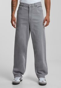 Gray wide-leg jeans made of denim, featuring front pockets, a button and zipper closure, and a clean, minimal design.