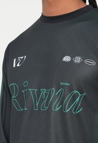 Pitkähihainen musta urheilupaita, jossa on vihreä teksti "Rivvia" sekä kolme graafista ikonia. Valmistettu teksturoidusta, kevyestä materiaalista, jossa on pyöreä kaula-aukko.