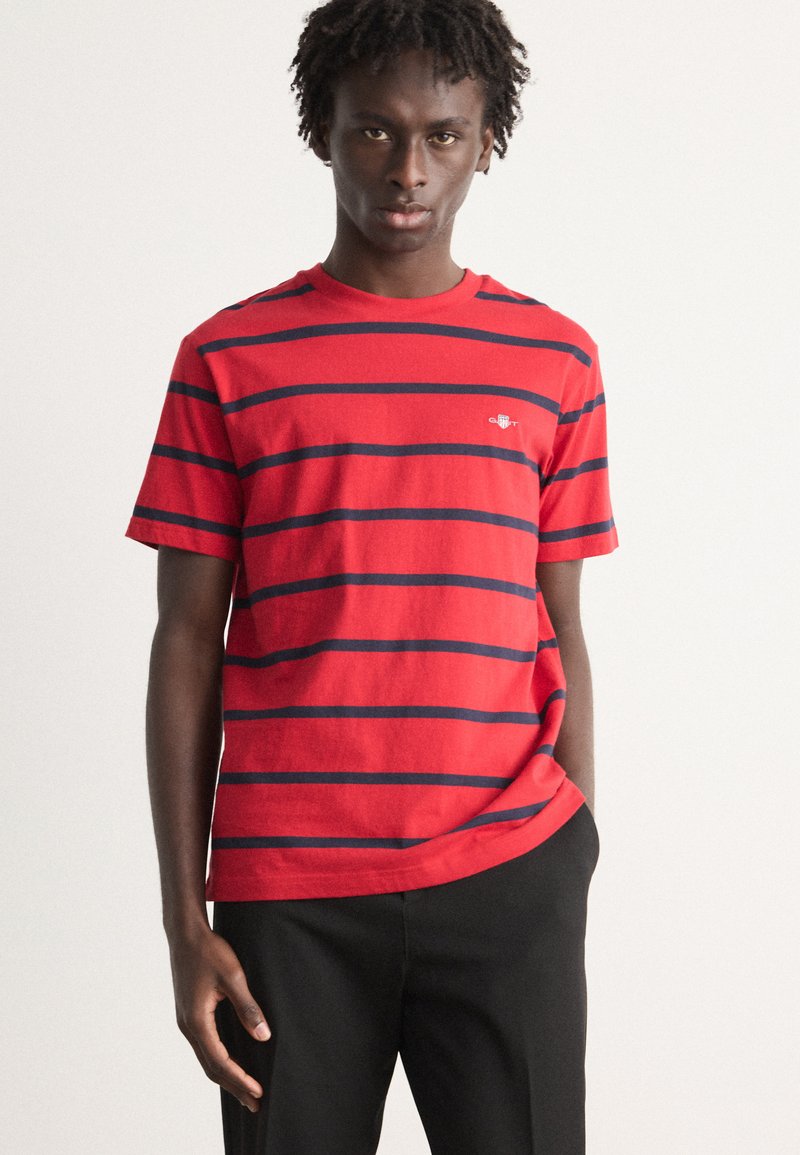 Rød og marineblå stribet kortærmet T-shirt lavet af bomuld, med rund hals og et lille logo på venstre bryst.