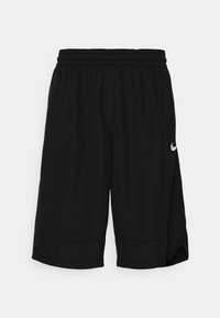 Pantalones cortos deportivos negros con cintura elástica, aberturas laterales y un pequeño logo blanco en el dobladillo inferior izquierdo. Tela suave y corte relajado.