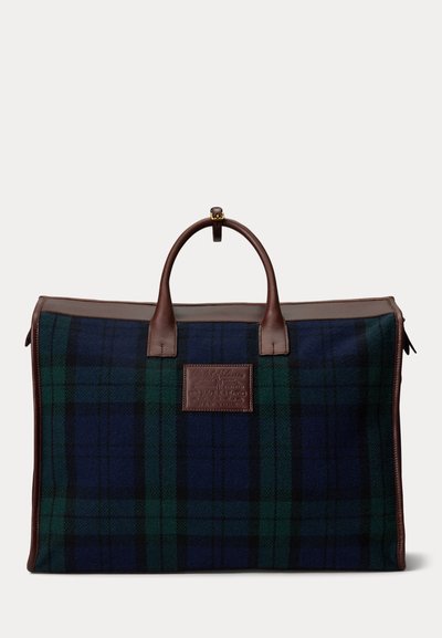 Ampia borsa da viaggio rettangolare a quadri verde scuro e blu navy con rifiniture e manici in pelle marrone, con patch logo in pelle centrale.