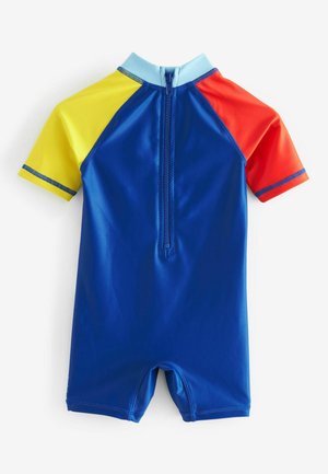 Mutino da surf per bambini a maniche corte di colore blu con sezioni gialle, rosse e azzurre. Presenta una chiusura con zip e un tessuto elastico e liscio.