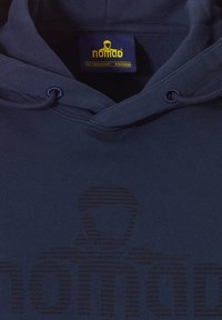 Marineblauwe hoodie met een trekkoordkap, voorzien van een subtiele grafiek in donkerdere tinten. De stof heeft een zachte textuur, met een prominent label met de tekst "nomad."