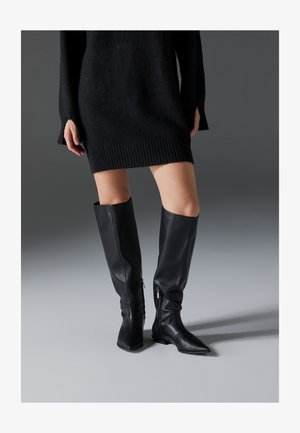 Crne kožne čizme do koljena s izvučenim prstima, ravnim potplatima i bočnim patentnim zatvaračima. Glatka tekstura, elegantan dizajn bez ukrasa.