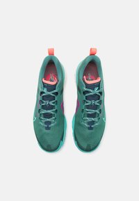 Laufschuhe aus teal- und grünem Mesh mit pinken Akzenten. Sie verfügen über einen gepolsterten Kragen, eine strukturierte Sohle und kontrastierende Schnürsenkel für einen sicheren Sitz.