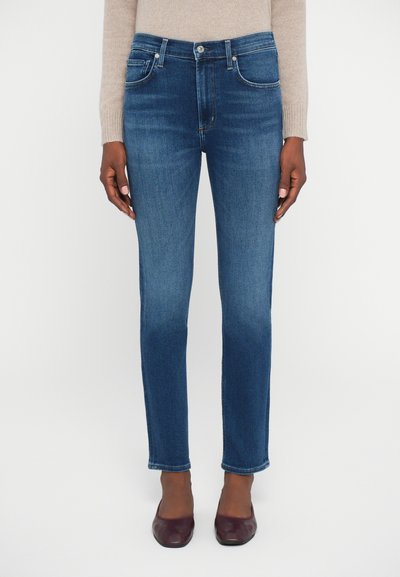 Jeans in denim blu scuro con vestibilità slim, design a cinque tasche e chiusura con bottone, caratterizzati da un leggero sbiadimento e dettagli di cucitura sottili.