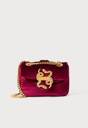 Crimson velvet handbag with a gold chain strap, featuring a snake-shaped clasp and structured design. Textured surface accentuates luxury.