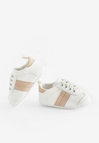 Zapatillas blancas con rayas de ante beige. Las características incluyen cordones, material texturizado y un diseño de punta suave y redondeada. Ligeras y flexibles.